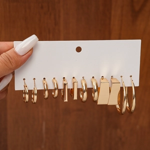 Detail view of 6 pairs of gold geometric C-shaped and round hoop earrings on display card