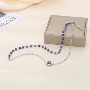 Detail of star pendant on necklace with half blue beads and half silver chain links