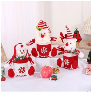Close-up of plush Santa, snowman and reindeer Christmas candy jars with knitted patterns