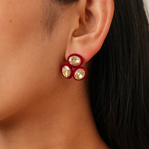 Detail of vintage velvet oval earrings with champagne crystals and red flocking texture