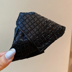 Detail of black velvet hair clip with rhinestone grid pattern and plush texture