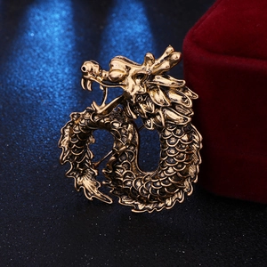 Detail of a vintage golden dragon brooch with intricate embossed texture for men suits