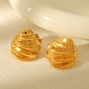 Macro shot of 18k gold plated stainless steel spiral shell earrings with shiny texture