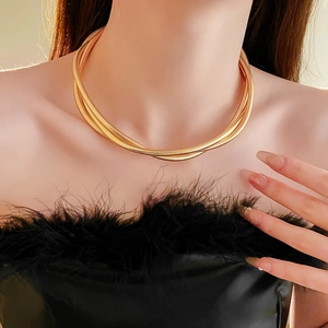 Gros plan d'un collier multicouche en maille serpent dorée au fini métallique