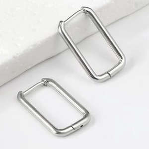 Polished silver stainless steel rectangular hoop earrings in a minimalist industrial style