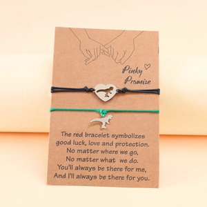 Detail of couple dinosaur promise bracelets with heart charms on display card