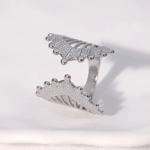 Close-up of silver geometric fan-shaped hollow ring with intricate metal cutouts