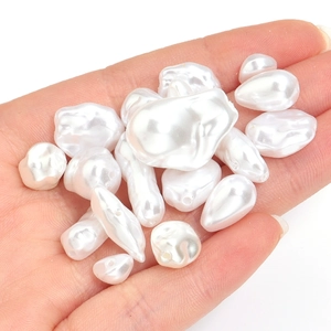 Hand holding irregular triangle white ABS faux pearl beads for DIY jewelry making