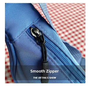 Close-up of smooth metal zipper with black woven puller on durable blue nylon bag