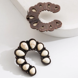 Detail of vintage bronze ethnic earrings featuring white stone inlays and geometric design