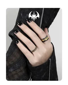 Close-up of gothic black and gold rings with irregular lava texture on hand