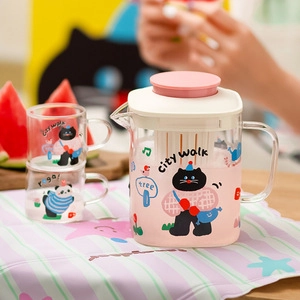 Detail of a portable glass pitcher set with pink base and two stacked matching glass cups