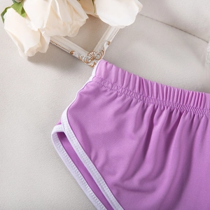 Detail von lila Sportshorts mit weißem Saum und elastischem Bund auf strukturiertem Grund