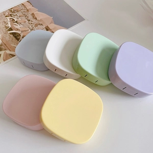Macro shot of candy-colored portable storage boxes for contact lenses or daily pills