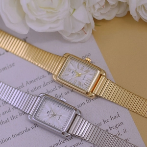 Close-up of square gold and silver quartz watches with Roman numeral dials and stretch bands