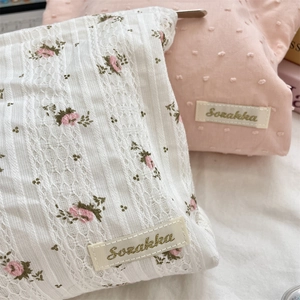 Detail of floral printed fabric and tufted dot texture on these portable cosmetic bags