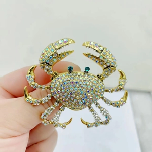 Close-up of golden crab brooch with colorful rhinestones and green crystal eyes