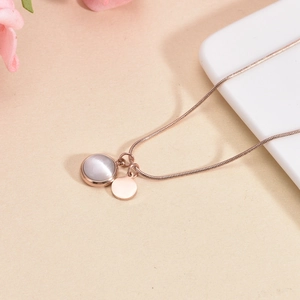 Elegant rose gold necklace with grey cat eye stone pendant and round metal disc charm