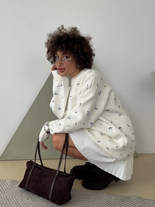 Oversized white floral crewneck sweatshirt with matching pleated skirt and brown suede tote bag
