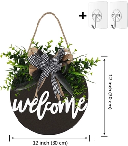 Detail of 12-inch round welcome sign with green foliage and black white plaid bow