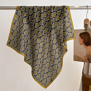 Close-up of elegant paisley pattern small square scarf with mustard yellow border detail