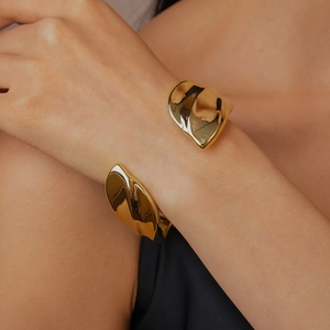 Macro detail of the polished gold irregular pleated texture on this open cuff bracelet