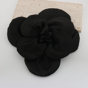 Detailed view of a 3D black fabric rose brooch with elegant layered flower petals