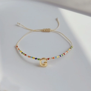 Detailansicht des bunten Miyuki-Perlenarmbands mit goldenem G und verstellbarem Band