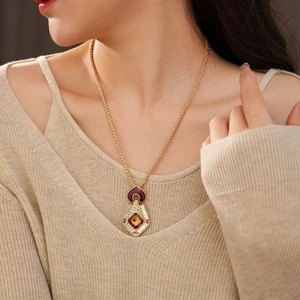 Close-up of vintage gold necklace with amber square pendant and ruby gemstones on a model