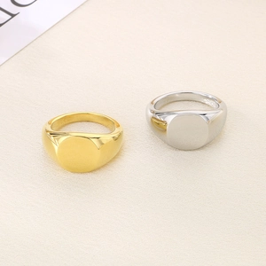 Close-up of polished gold and silver round signet rings on textured fabric