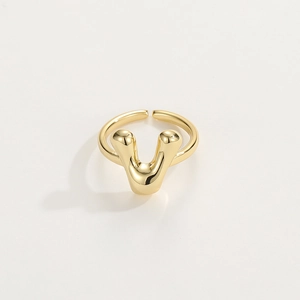 Macro detail of adjustable golden letter ring showing smooth 18K plated finish