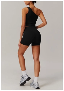 Détail d'un haut de yoga asymétrique noir et d'un short de fitness taille haute