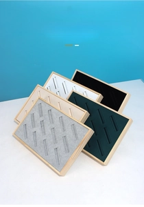 Detailed view of wood jewelry tray with multi-color velvet slots for bracelet display