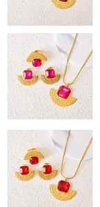 Flat lay of vintage fan-shaped jewelry set with red gems and golden hammered texture