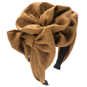 Detailed view of the brown textured jacquard headband featuring a large bow design