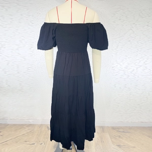 Detail of black off-shoulder maxi dress with puff sleeves and tiered ruffle skirt