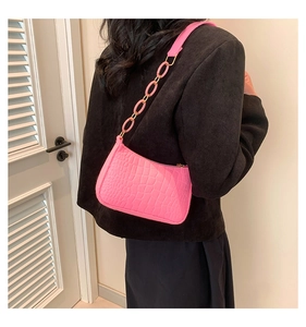Detail of pink faux crocodile leather small square bag with matching plastic chain strap