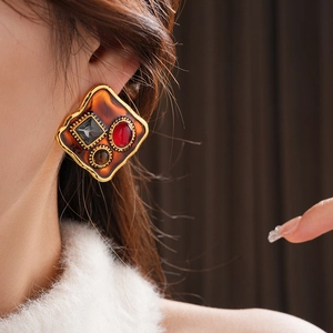 Gros plan de boucles d'oreilles vintage avec œil de tigre et diamants sur modèle