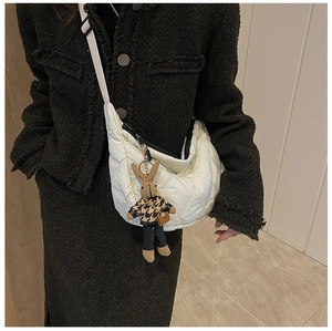 Close-up of white quilted crossbody bag featuring a cute houndstooth bunny charm detail
