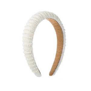 Close-up of wide baroque sponge headband with hand-set pearls and brown suede lining