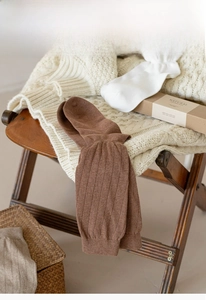 Gros plan sur des chaussettes en tricot côtelé marron et blanc avec boîte cadeau