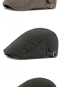 Detail view of herringbone newsboy caps with side metal buckles in grey and green