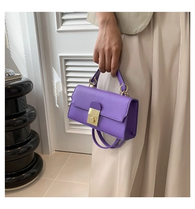 Detail of purple leather crossbody bag with golden buckle and ring handle decoration