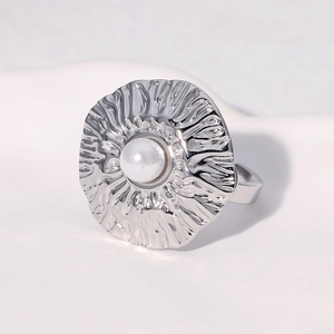 Detailed macro shot of a silver textured ring with a central white pearl inlay