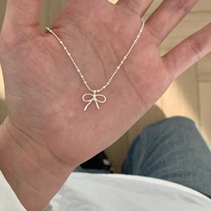 Detailed close-up of a silver butterfly pendant necklace with a delicate bead chain