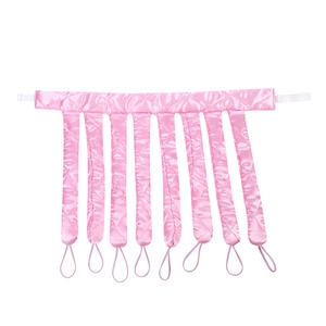 Detail of pink satin heatless hair curler with quilted octopus style straps and fasteners