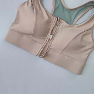 Detail showing the front zipper closure and breathable grey mesh back of this pink sports bra