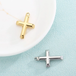 Polished gold and silver cross pendants for necklaces on minimalist display