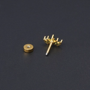 Vue macro d'un clou d'oreille fleur en or 18K serti de zircons verts et transparents