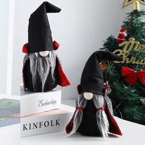 Halloween gnomes in black vampire cloaks and hats placed on books for festive decoration